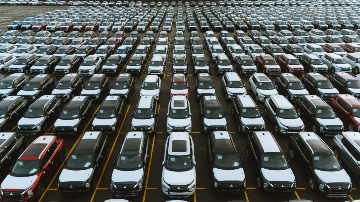 Rows of cars parked on a dealership lot under afternoon light