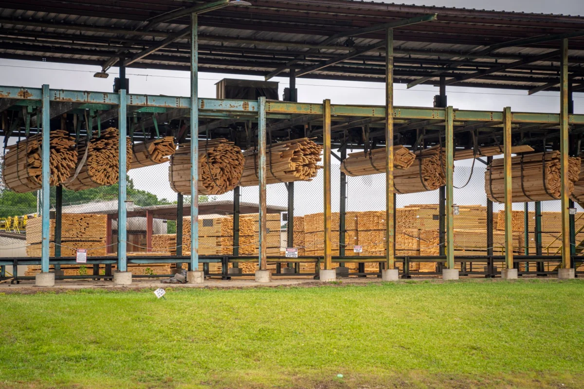 Stacked rough-cut lumber boards at a sawmill yard