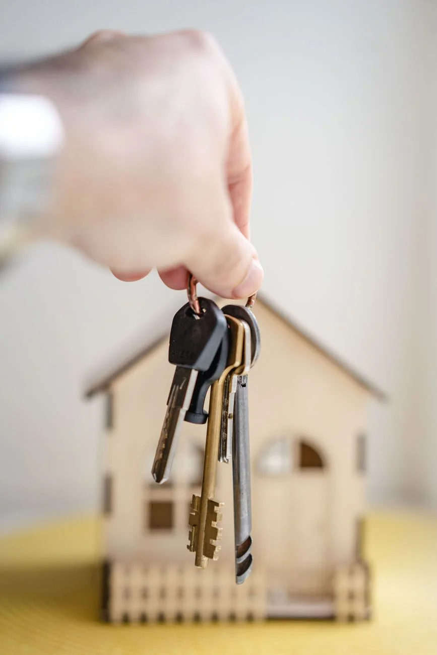 A set of house keys resting on a closing document next to a pen