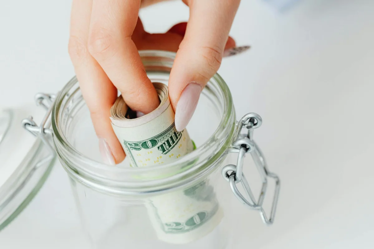 Glass jar filled with coins representing emergency savings fund building