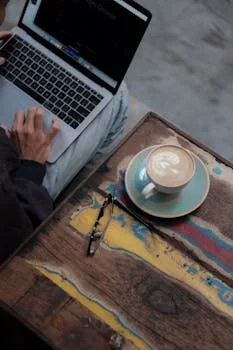 Freelancer working on laptop at a desk with coffee and calculator