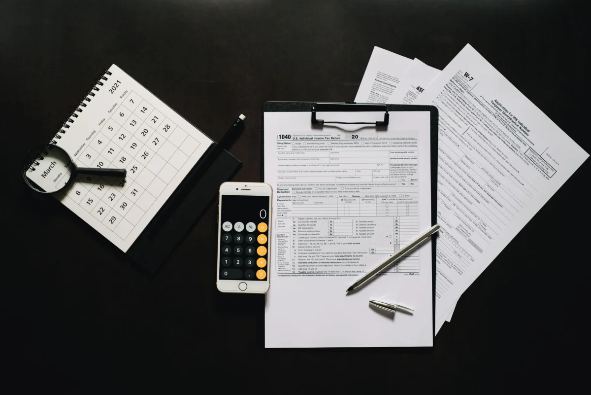 Tax forms and a calculator on a wooden desk representing quarterly tax planning
