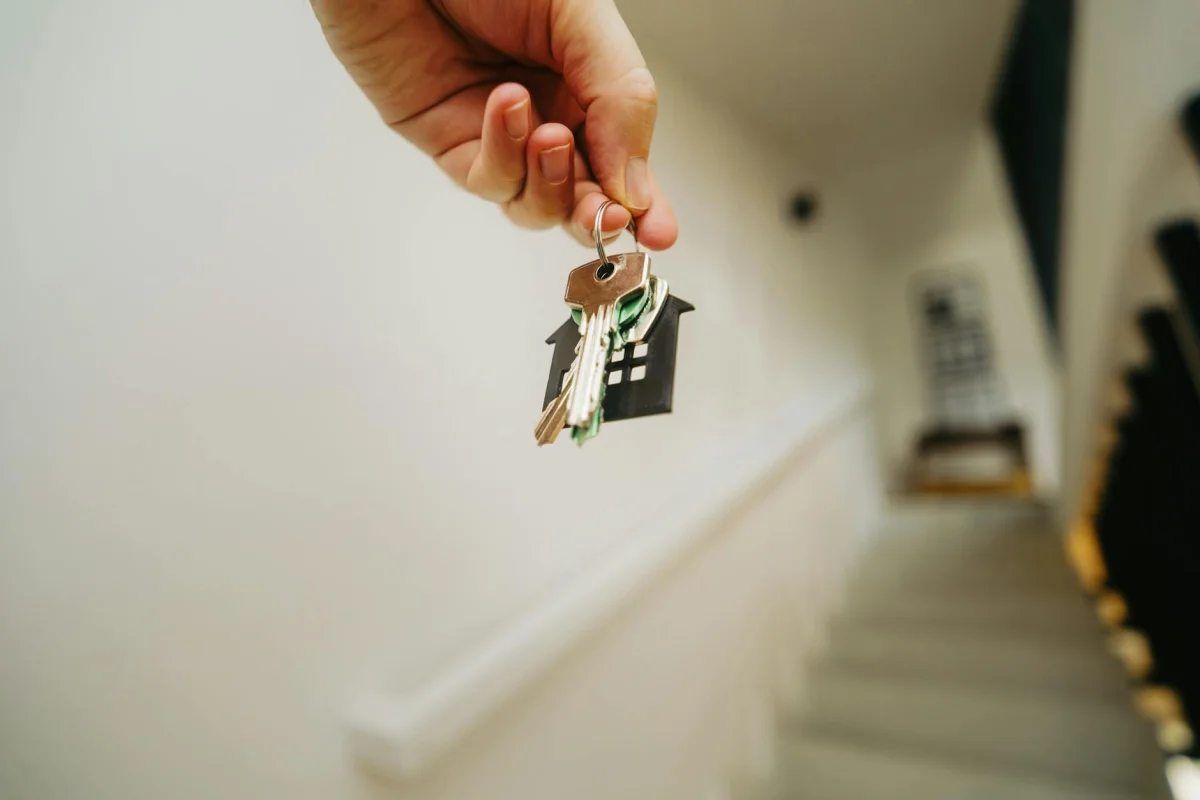 A set of house keys resting on a wooden door representing homeownership