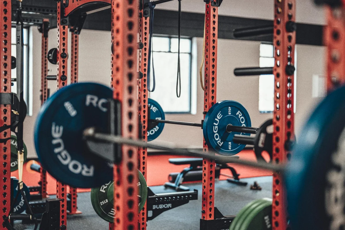 Athlete performing resistance training with barbells representing structured progressive workout planning