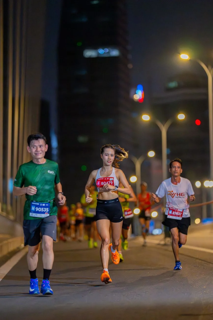 Runners racing along a city marathon route while checking pace