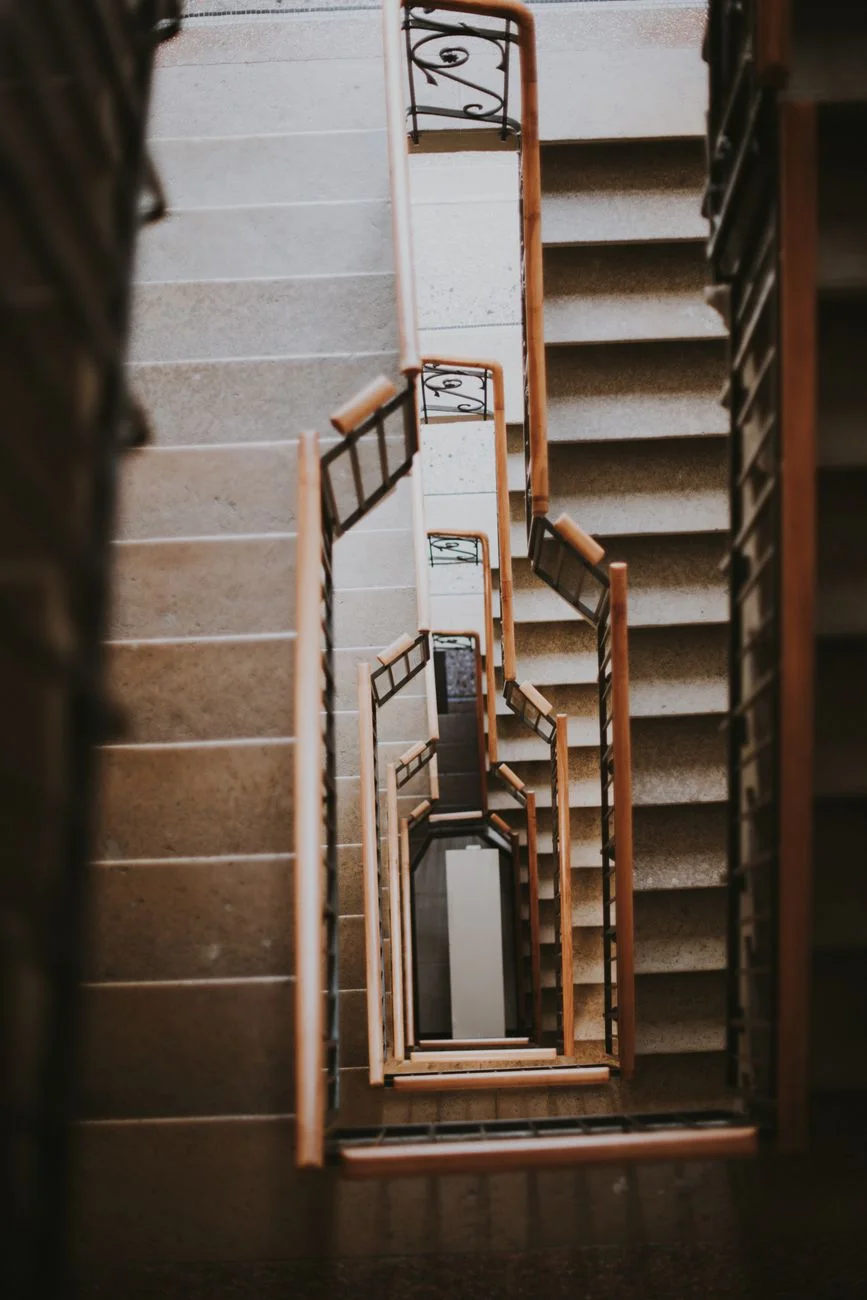 A carpenter measuring a wooden stair stringer during staircase framing
