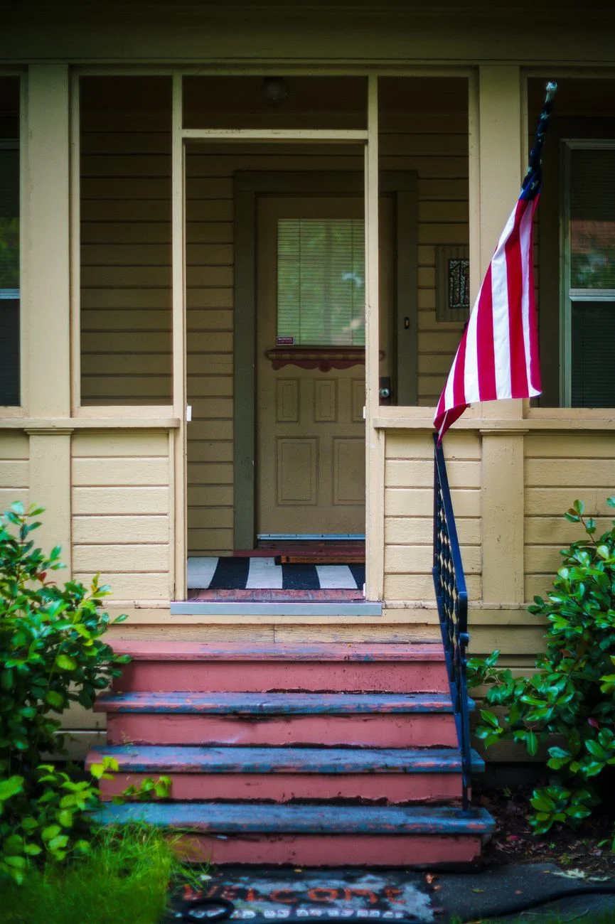 A suburban home with a porch on a quiet residential street