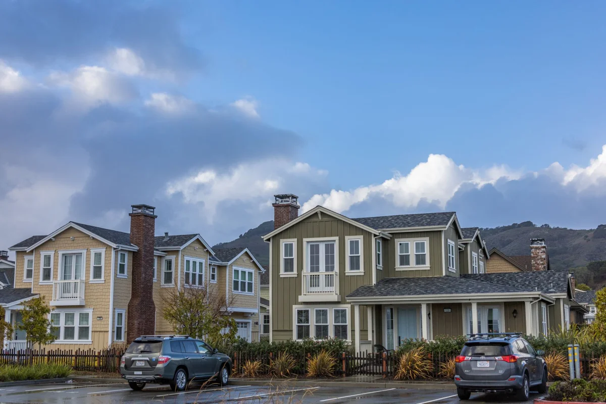 A two-story house on a quiet residential street on a sunny afternoon
