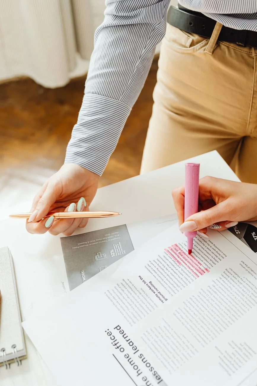 A printed document with highlighted passages and pen notes in the margins