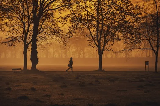 Runner jogging on a trail at sunrise with a smartwatch visible