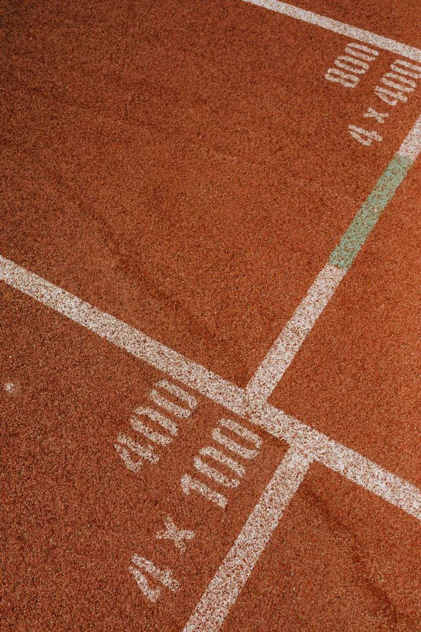 A pair of running shoes crossing a track lane line at speed
