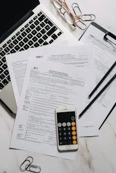 Freelancer calculating quarterly taxes with documents and a calculator on a desk