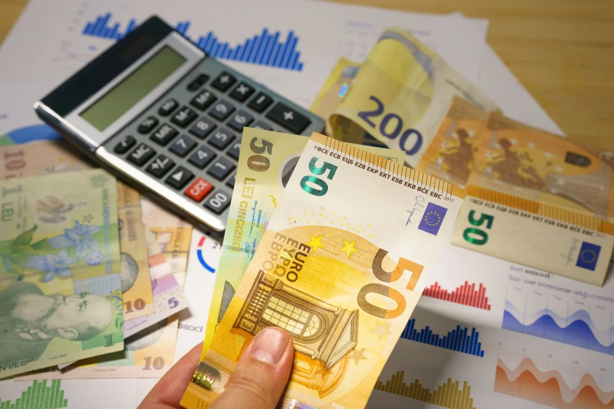 A calculator and pay stub sitting on a desk, representing converting salary to an hourly rate