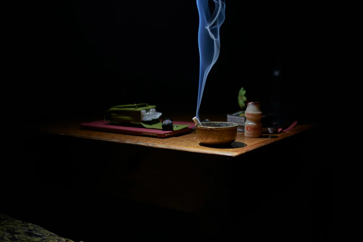 An ashtray with cigarette butts next to a pack of cigarettes