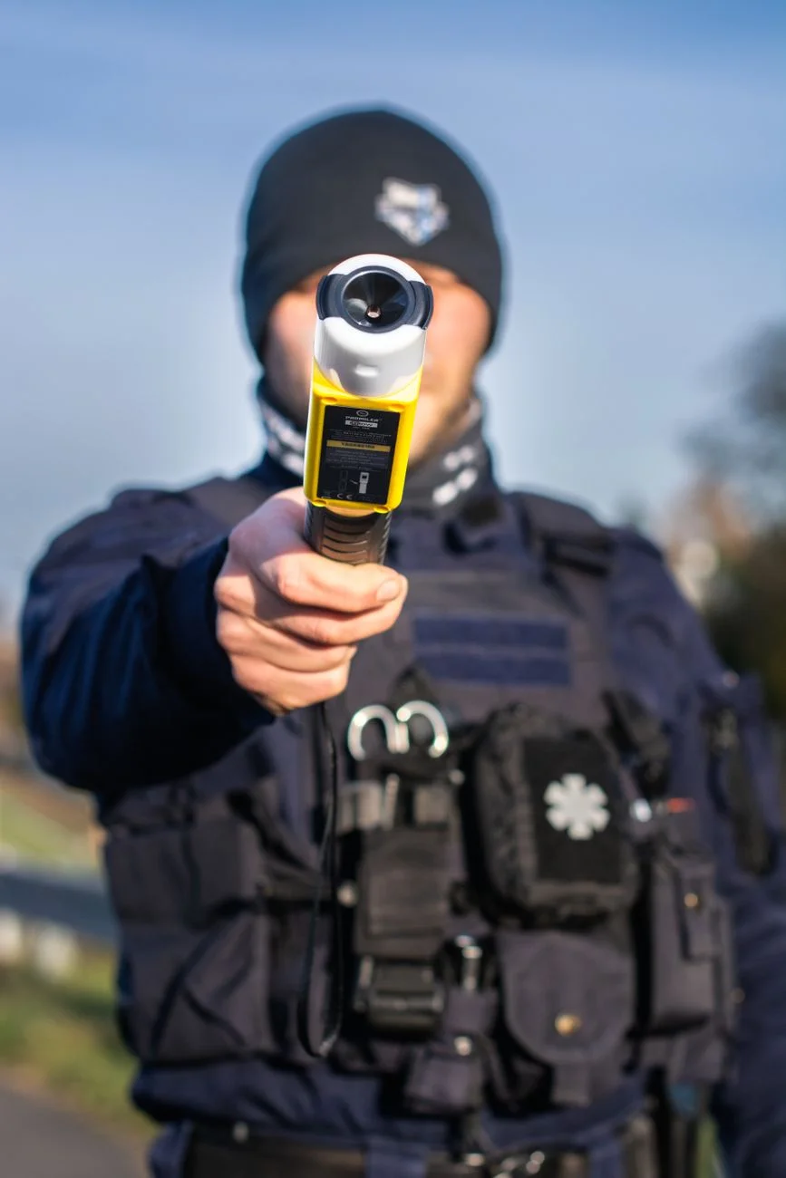 A handheld breathalyzer style device resting on a table