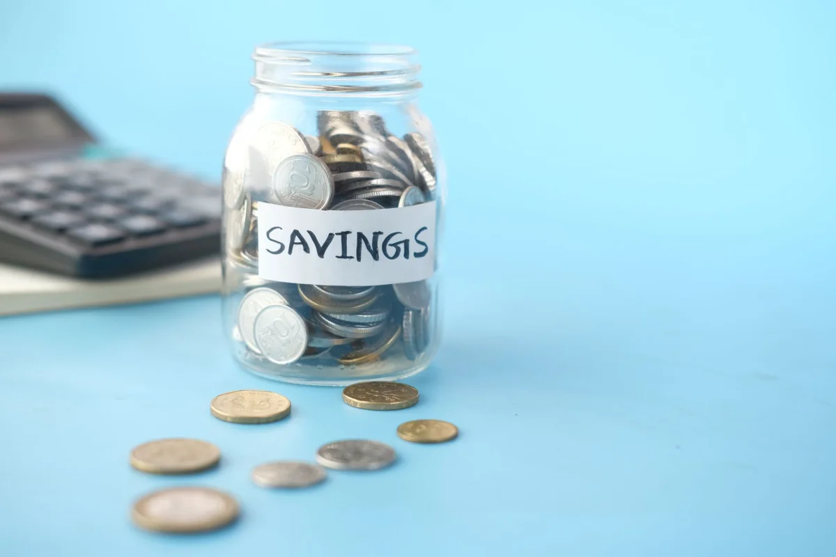 A piggy bank surrounded by loose coins representing a savings goal that needs adjusting