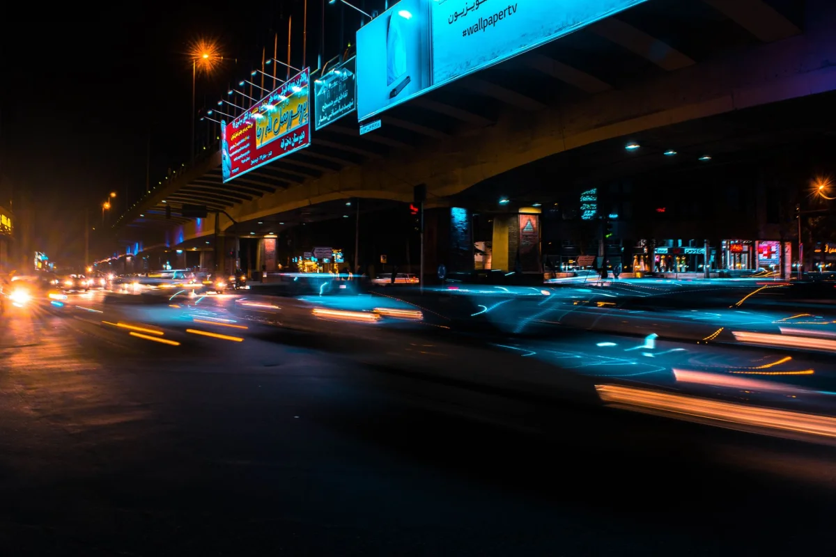 A bright illuminated billboard glowing above a city street at night