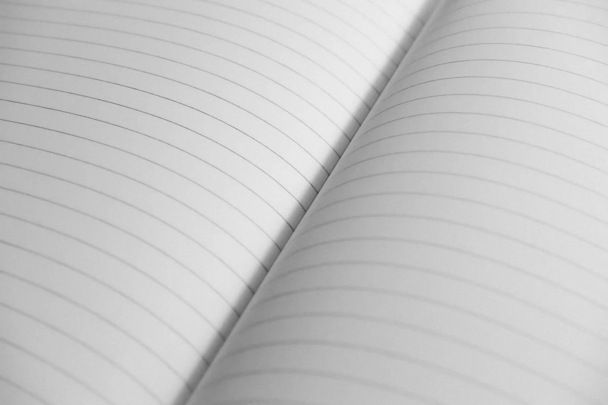 Open notebook with handwritten pages on a wooden desk