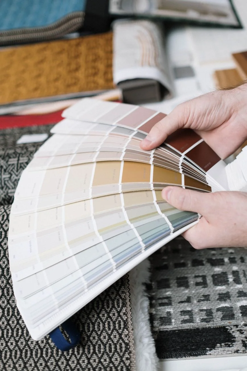 A row of color swatches and paint chips arranged on a table