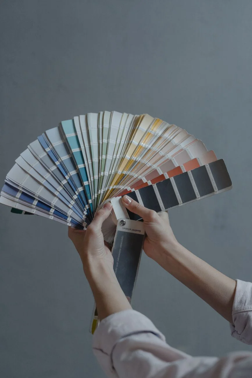 A fan deck of paint swatches spread out on a worktable