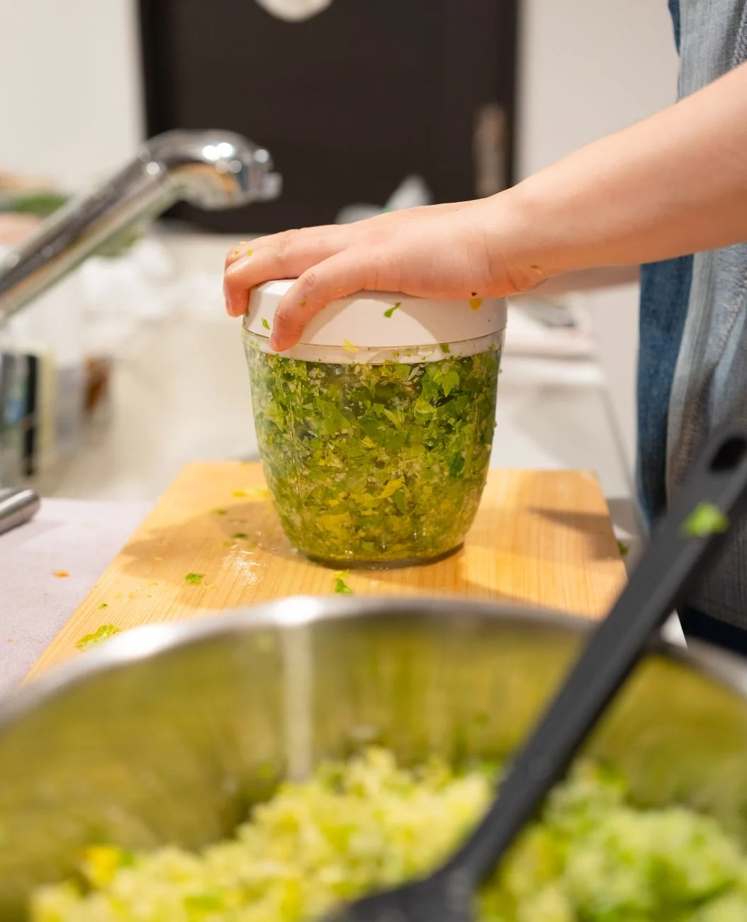A small kitchen scale with fresh herbs and ingredients arranged on a wooden cutting board