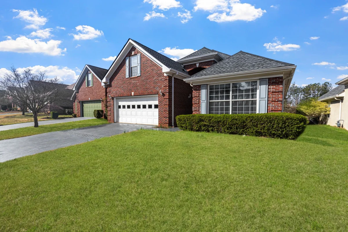 Suburban two-story house with a covered front porch, photographed from the curb on a sunny day