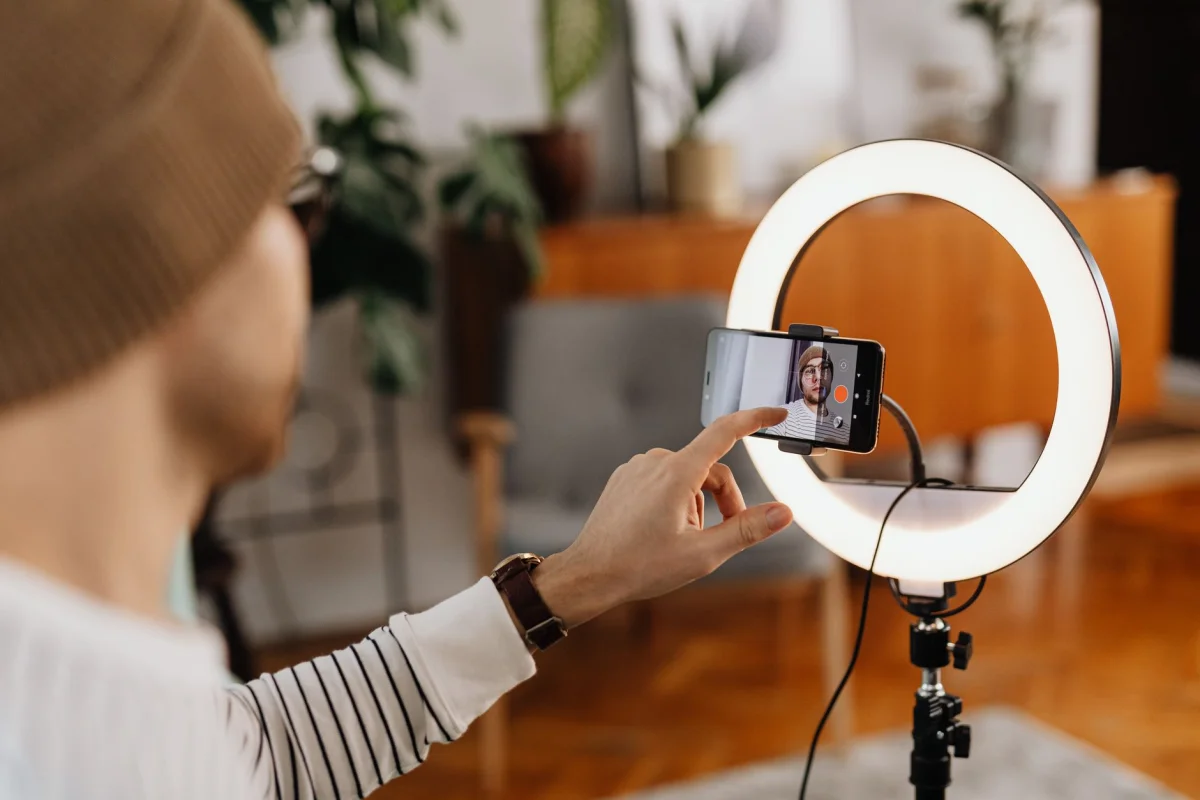 A smartphone mounted on a ring light stand, set up for content creation