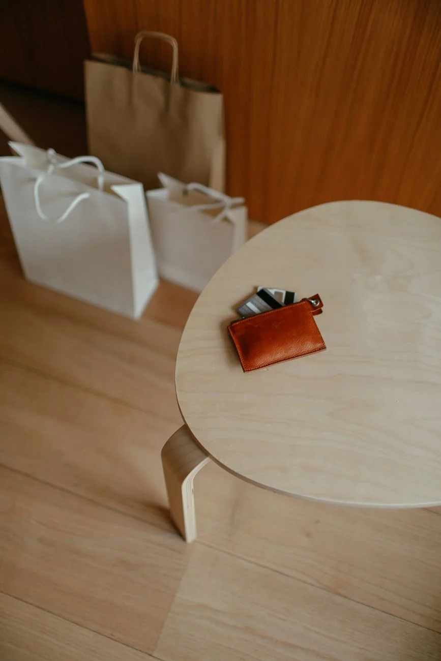 A leather wallet with several credit cards fanned out on a table