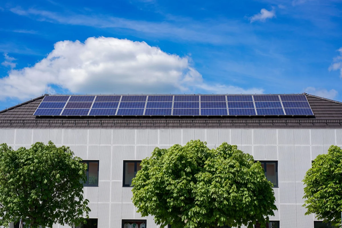 Rows of solar panels installed on a residential rooftop under a clear blue sky
