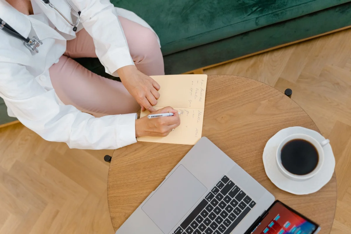 A stethoscope resting on a notebook on a clinic desk