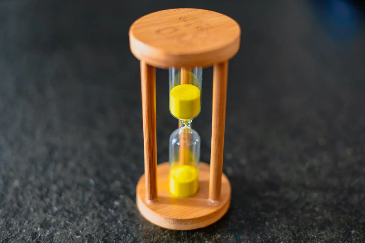 An hourglass with sand running through it sitting on a desk, representing time slipping away from billable work