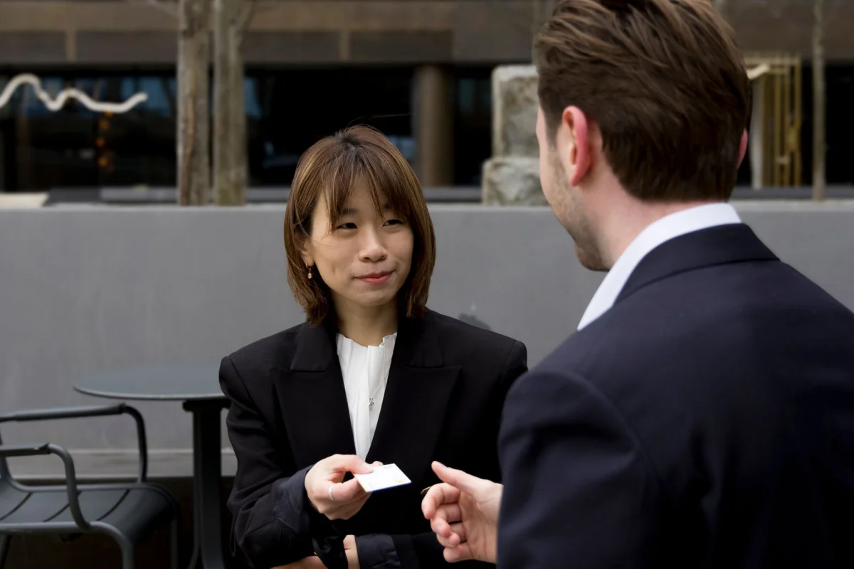 Two professionals exchanging business cards at a networking event