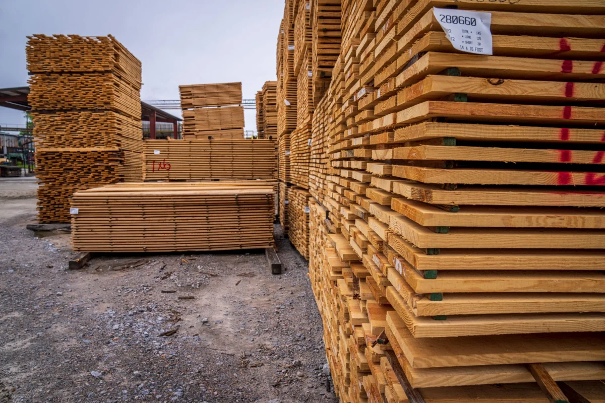 Stacked rough lumber boards at a sawmill yard ready for pickup